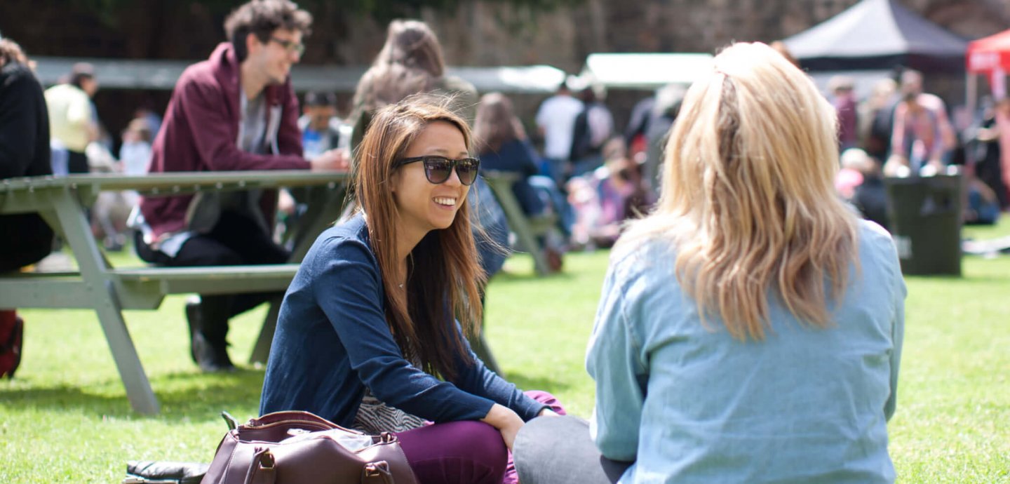 Women sitting on the grass at Kirkstall Festival